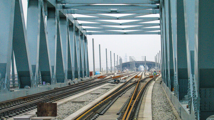 Schienen mit Stahlträger über dem Schienenweg