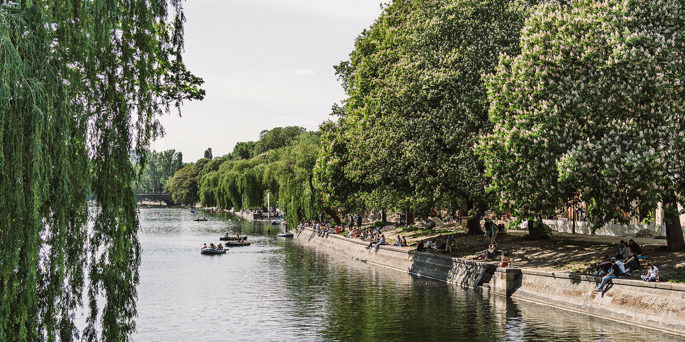 Fluss mit Ufer und Menschen im Wasser