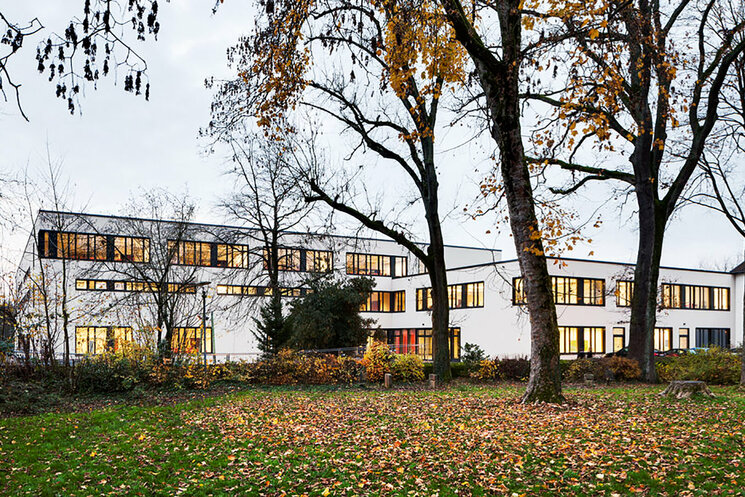 Außenansicht Gebäude mit Wiese und Bäumen