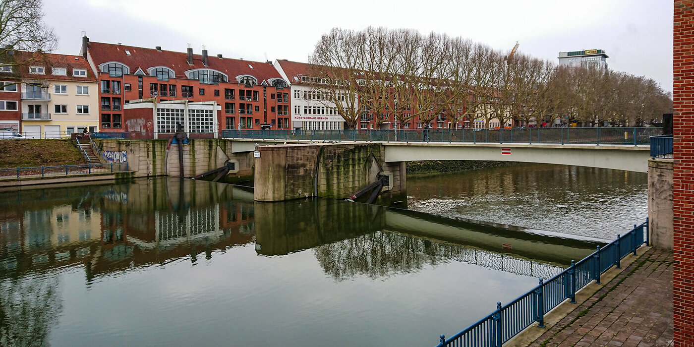 Wehr Ansicht mit Brücke und umgeben von Gebäuden