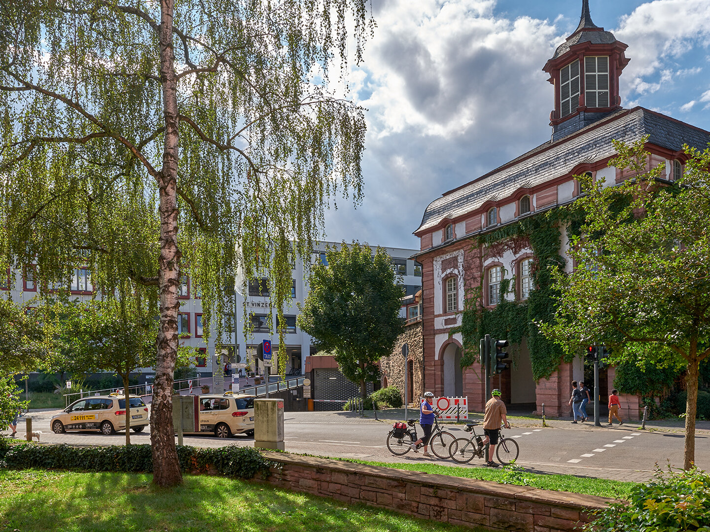 Gebäude angrenzend an Straße mit Fahrradfahrern