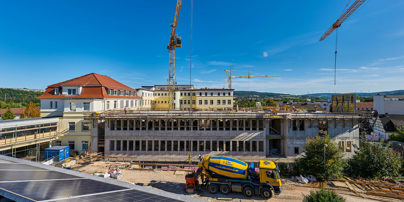 Gebäude im Bauzustand mit Bauwagen vor dem Gebäude