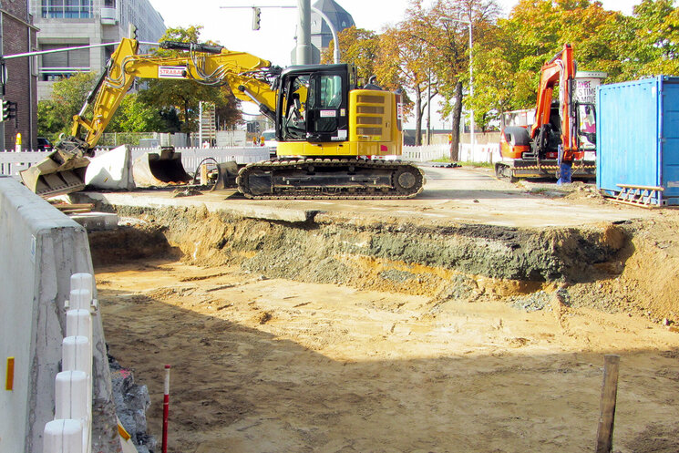 Straße im Bauzustand mit gelben Bagger