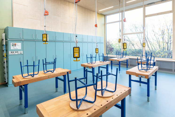 Klassenzimmer mit Tischen und hochgestellten Stühlen