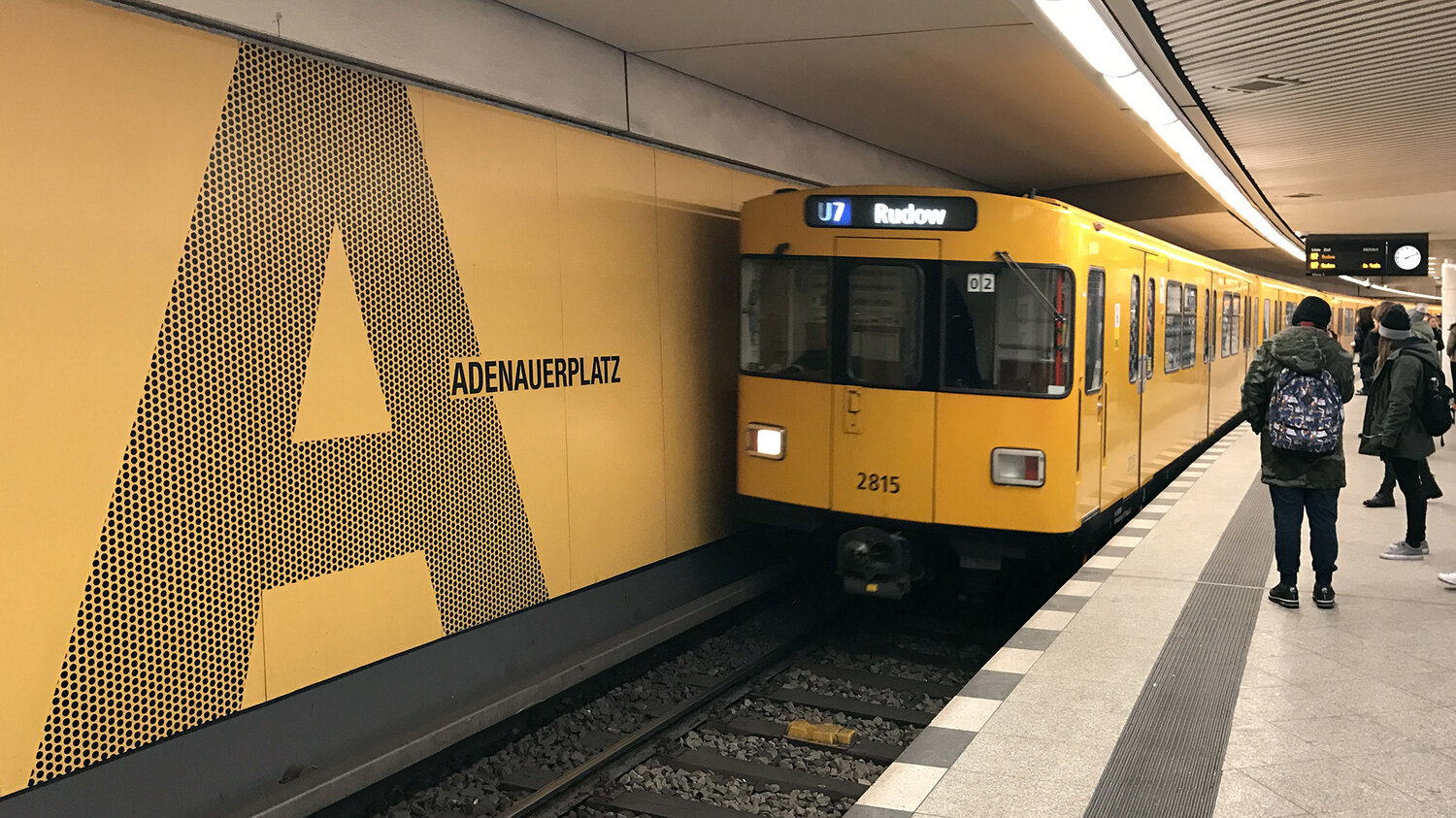 Schienen mit gelbem Zug und Fußgängern