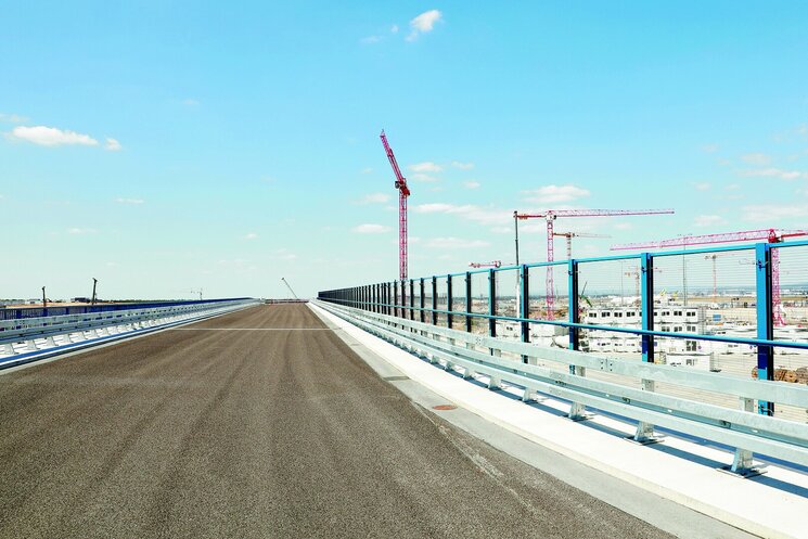 Straße mit Kränen im Hintergrund