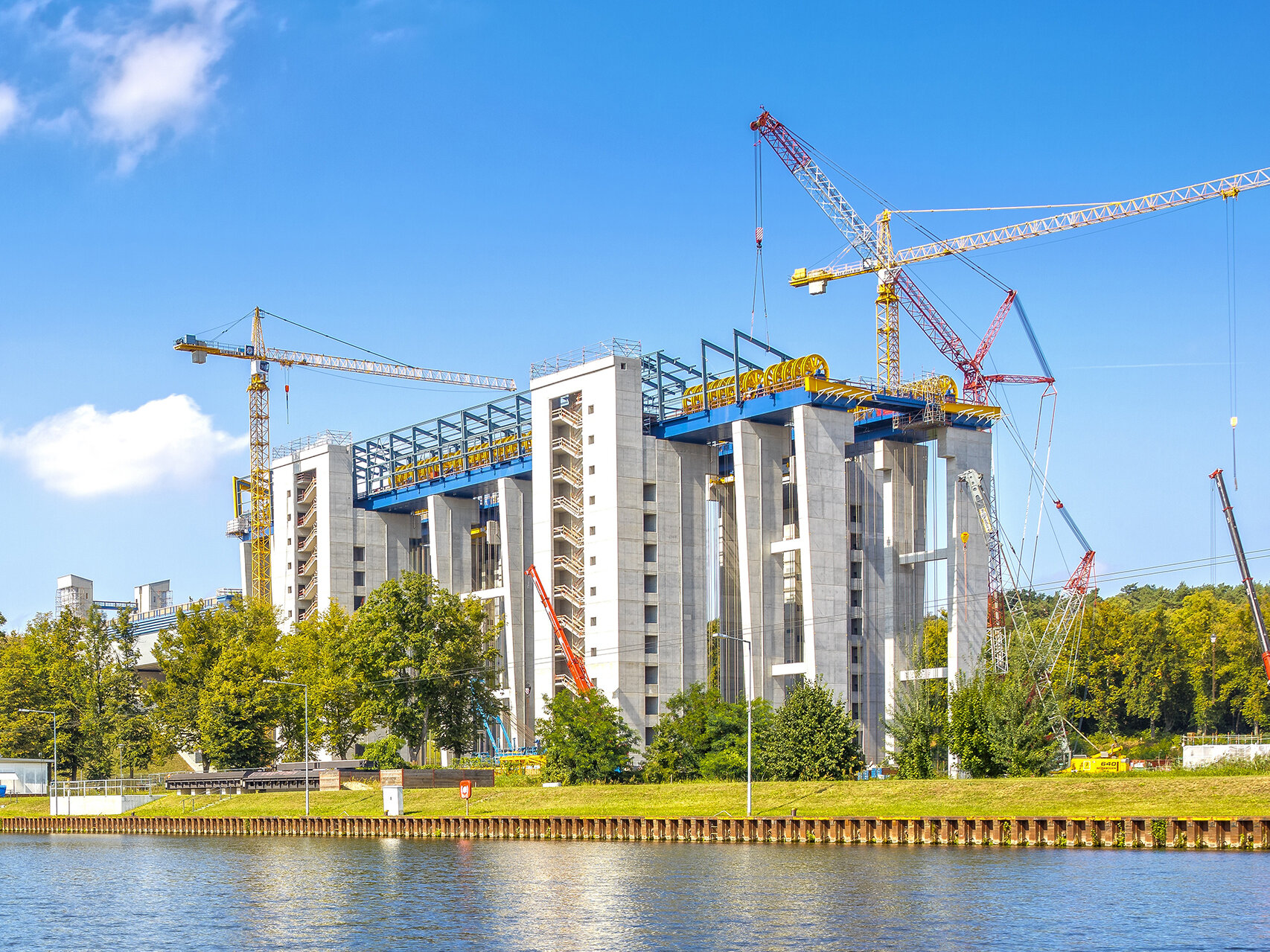 Bauzustand Gebäude in der Nähe von Wasser und umgeben von Kränen