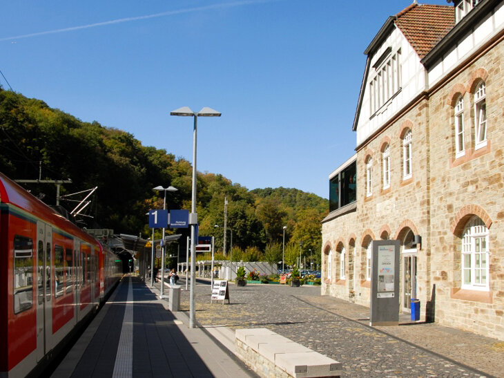 Roter Zug mit Gebäude nebendran